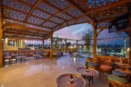 Lounge under a carved arabesque ceiling opening onto the pool
