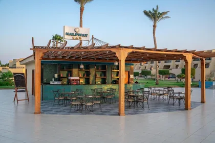Timber-pergola beach bar with seating open to the shore