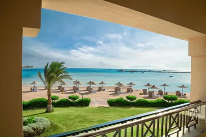 View from a guest balcony across the gardens to the beach and sea