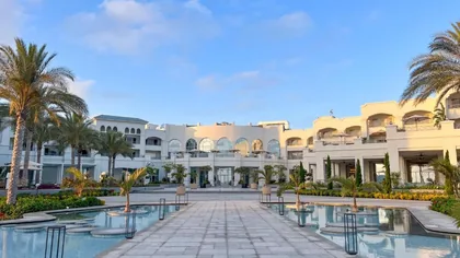 The arrival court with palms and a reflecting pool in front of the resort