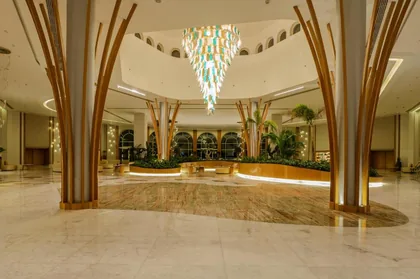 Lobby with sculpted palm-form columns and a hanging light installation