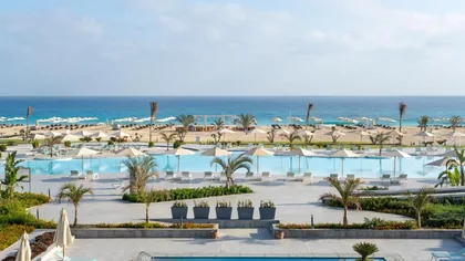 The resort's pools stepping down to a white-sand beach and turquoise sea
