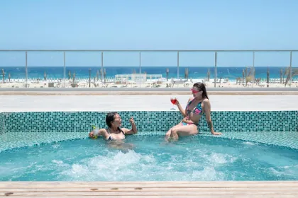 Guests in the raised pool with the sea beyond