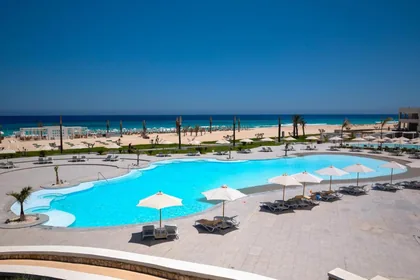 Freeform pool beside the beach with the sea filling the horizon